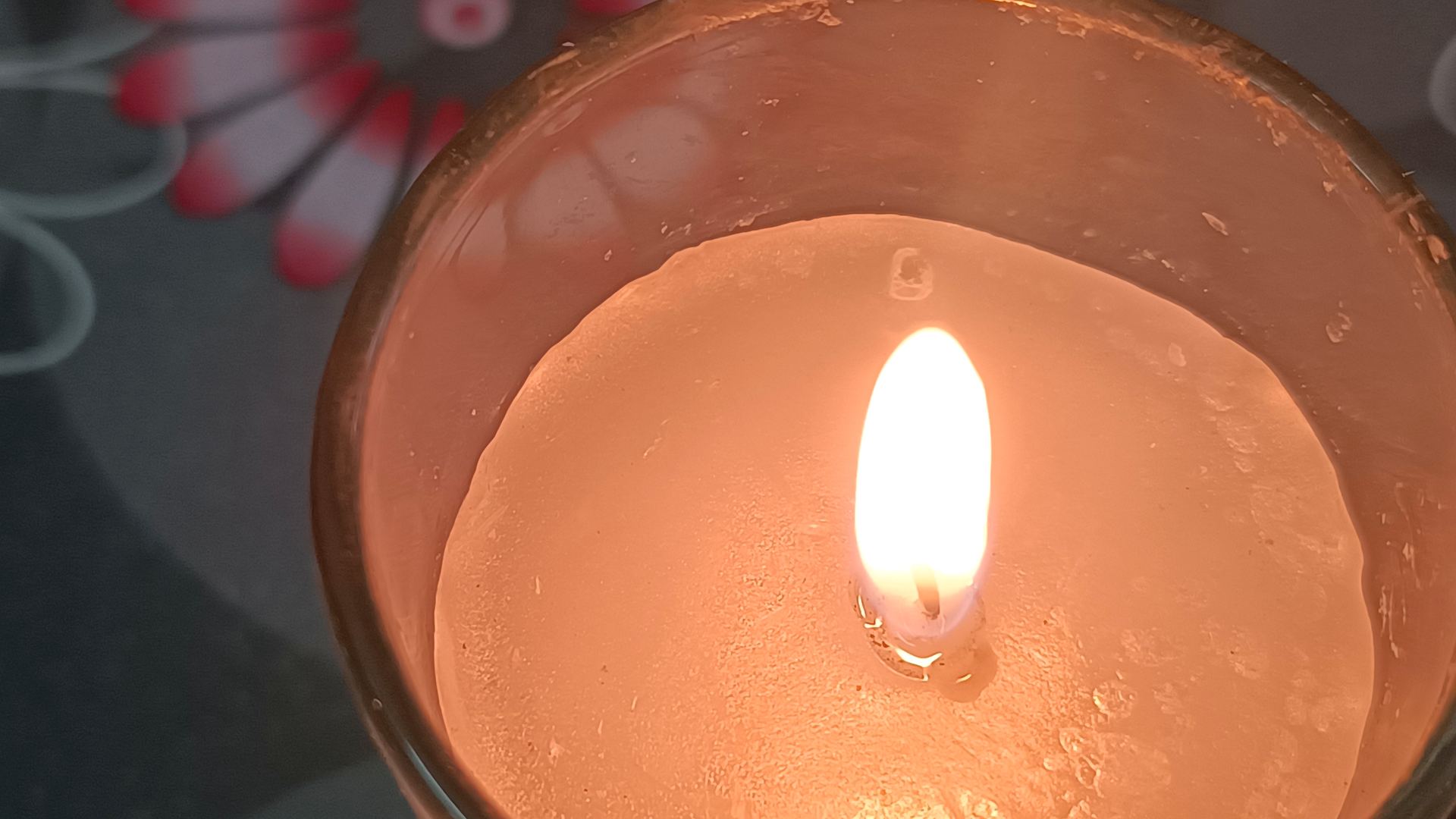 Lit handmade candle glowing in a glass holder, poured in Jaipur