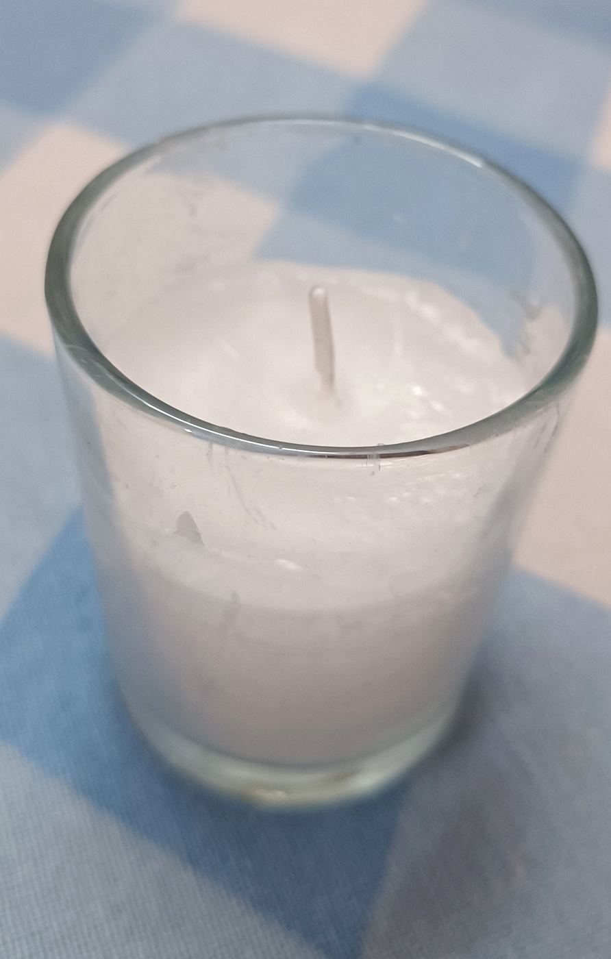 White tealight candle holder manufactured in a clear glass cup